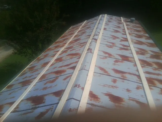 Rusted metal roof panels with new wood purlins before replacement — Storm Damage Roof Repair in Maple by Roofing Brothers