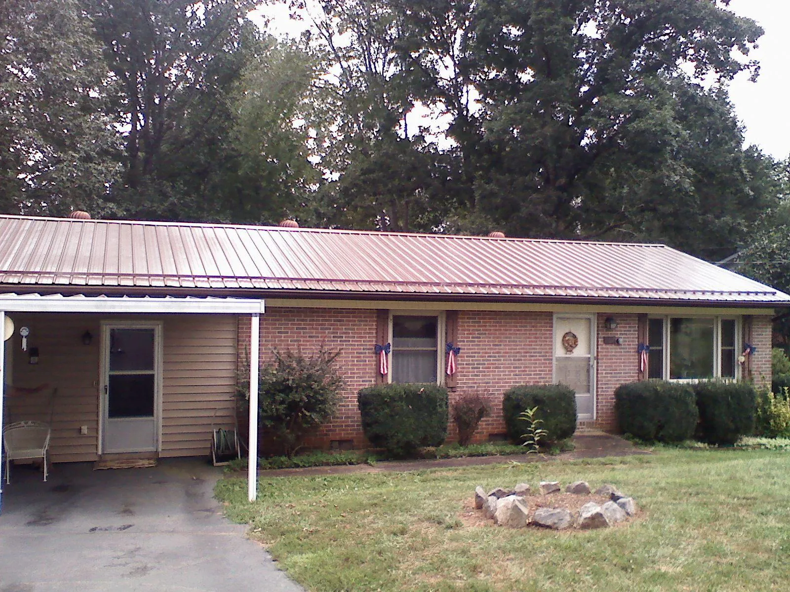 Bronze metal roof and carport on a brick ranch home — Roof Repair work by our crew in Maple